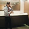 Furious Business Man Screaming On Cell Phone In Office Restroom