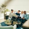 Group of young businesspeople sitting on a sofa discussing work