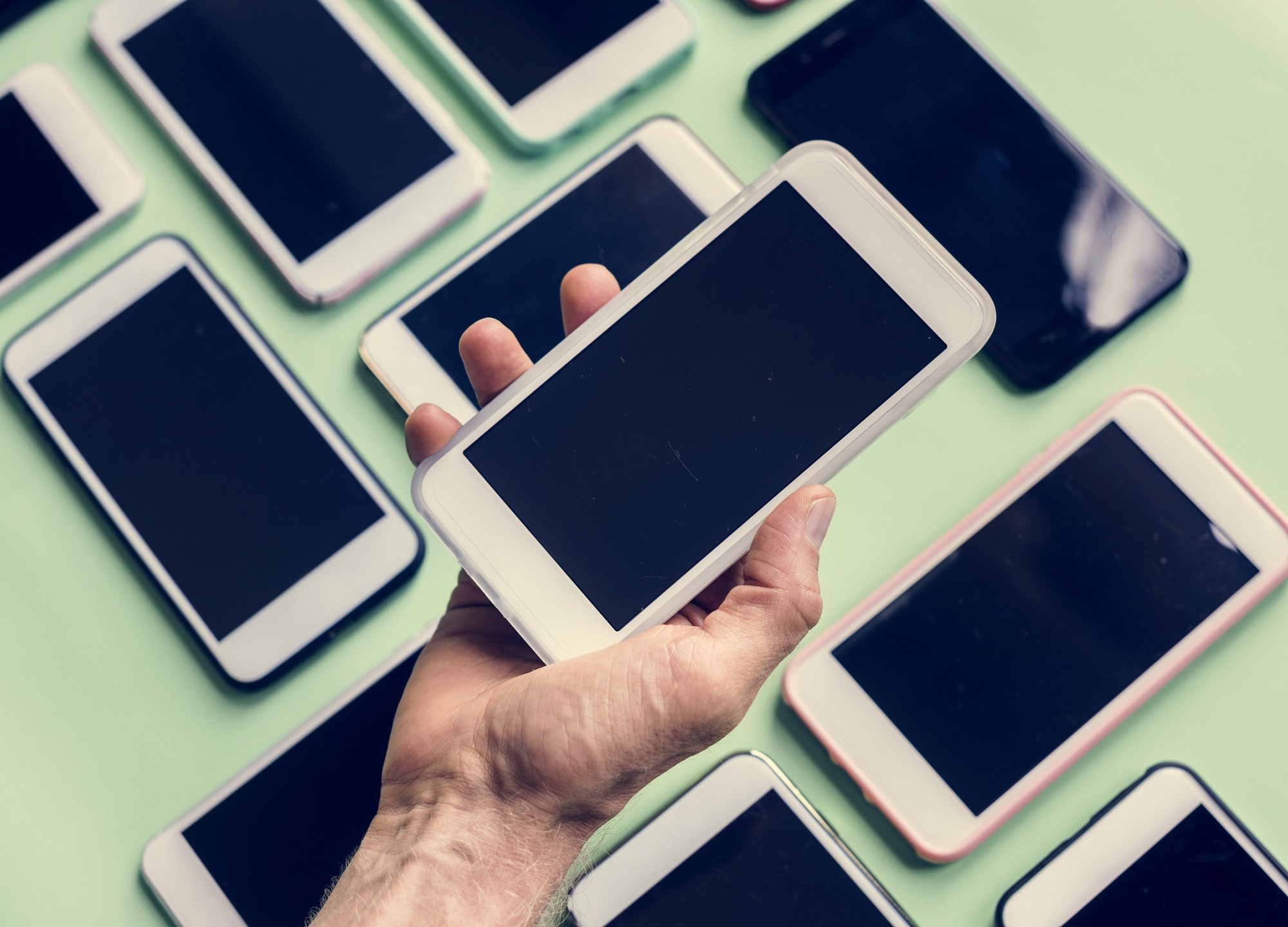 Hand holding smartphone with smartphone on background