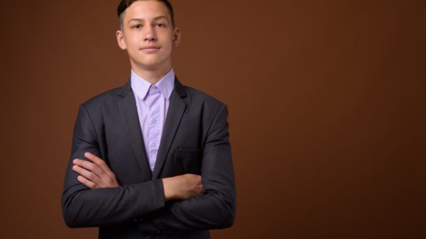 Studio shot of young handsome businessman against brown backgrou