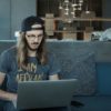 Young man using a laptop computer to do business in an airport lounge before traveling. Entrepreneur