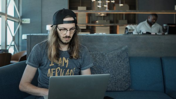 Young man using a laptop computer to do business in an airport lounge before traveling. Entrepreneur