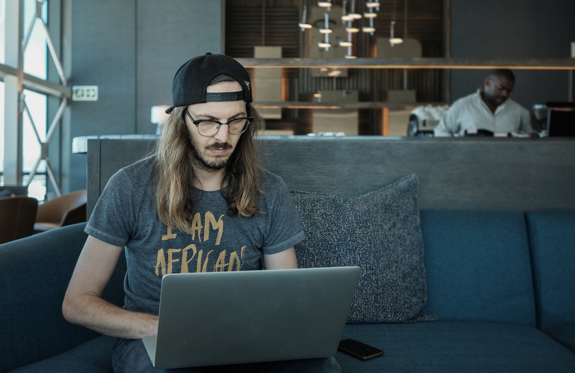 Young man using a laptop computer to do business in an airport lounge before traveling. Entrepreneur