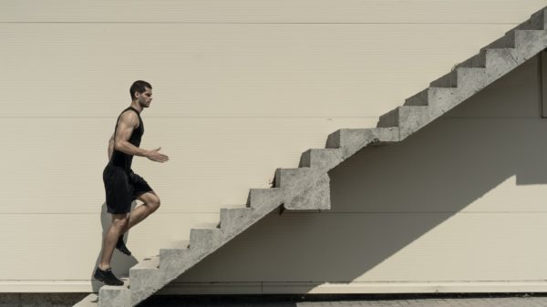 Concept of success and achieving your goal, man climbing stairs.