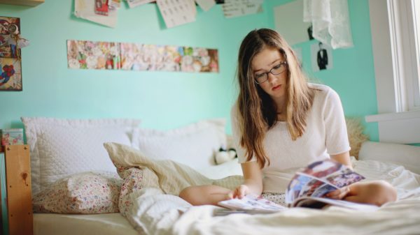 teen reading on her bed