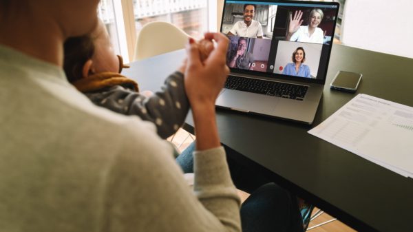 Woman at home video conferencing with colleagues