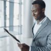 Black businessman with newspaper, office building