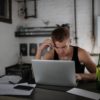 Concentrated freelancer browsing laptop