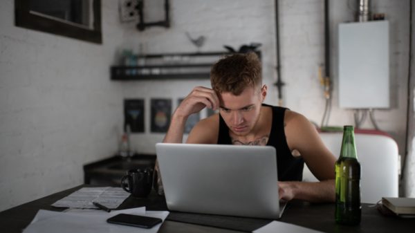 Concentrated freelancer browsing laptop