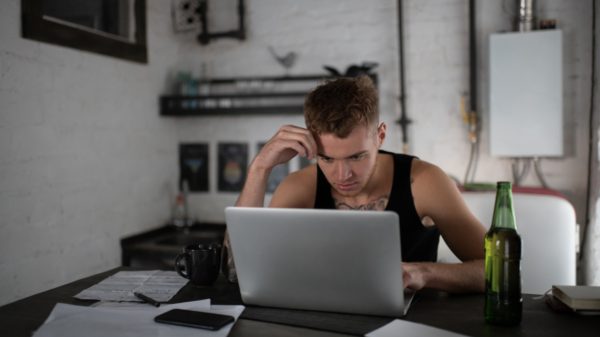 Concentrated freelancer browsing laptop